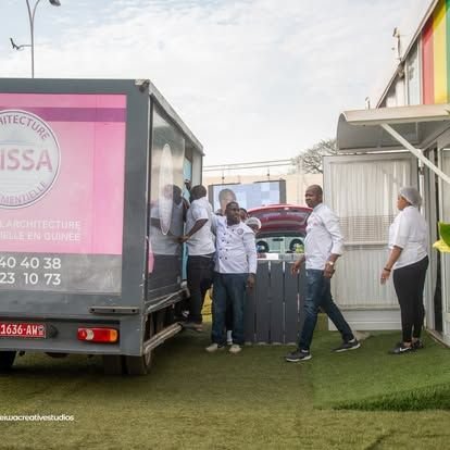 Équipe BY ISSA en tenue blanche devant le camion de livraison