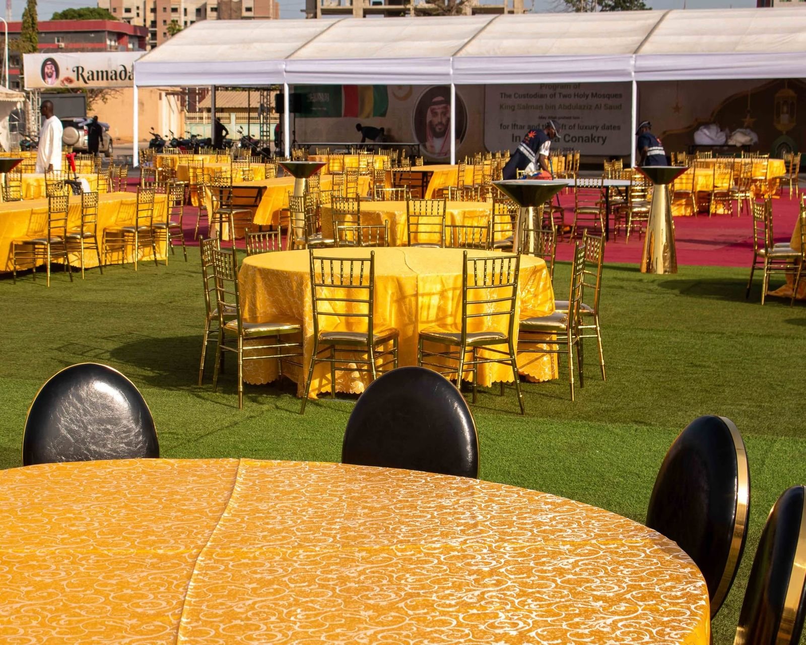 Tables rondes nappées jaune et chaises dorées
